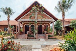 Red-brick bungalow entrance with a flower garden
